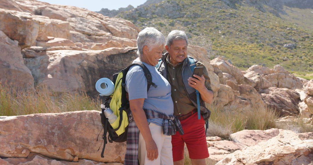 Active Senior Couple Exploring Nature with Smartphone GPS