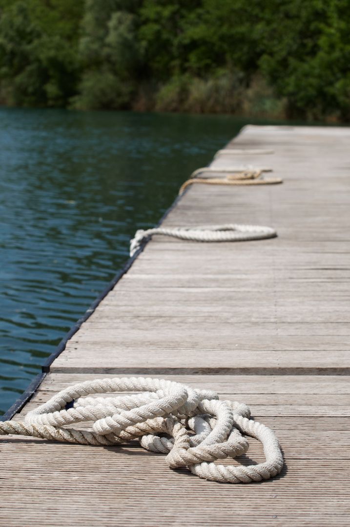 Coiled Rope on Wooden Dock by Tranquil Lake - Free Images, Stock Photos and Pictures on Pikwizard.com