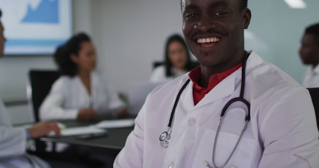 Smiling Doctor in White Coat with Colleagues in Background - Free Images, Stock Photos and Pictures on Pikwizard.com