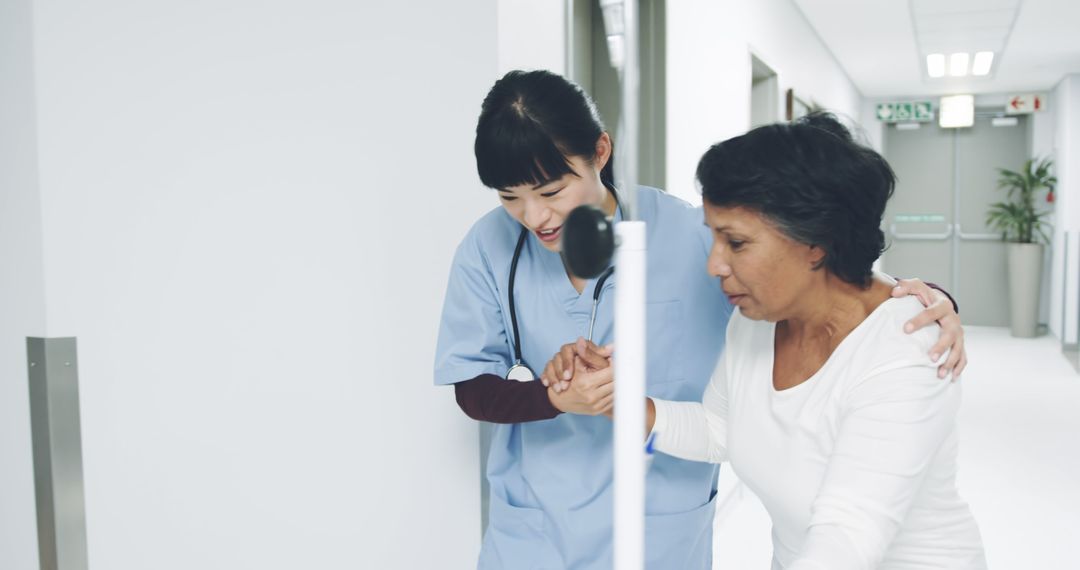 Nurse Assisting Elderly Woman in Hospital Corridor - Free Images, Stock Photos and Pictures on Pikwizard.com