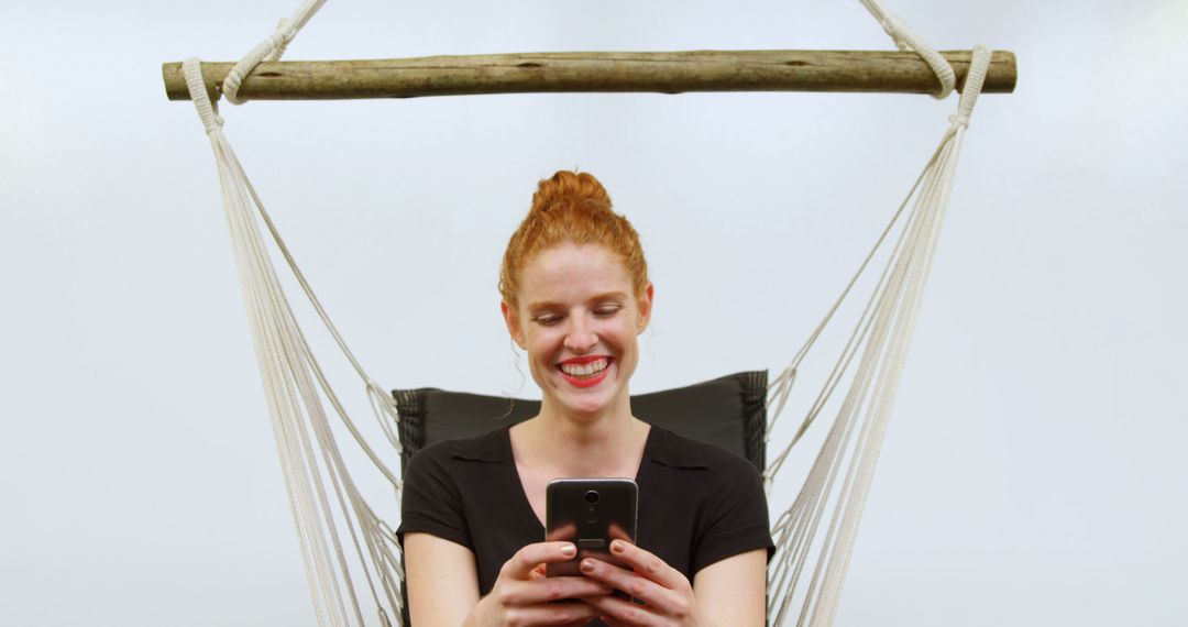 Smiling Woman Relaxing in Hammock Chair Using Smartphone - Free Images, Stock Photos and Pictures on Pikwizard.com