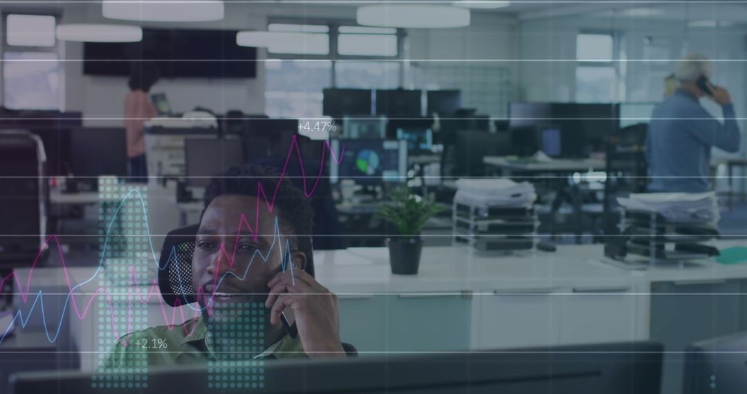 Businessman Analyzing Graphs Amid Dynamic Office Environment