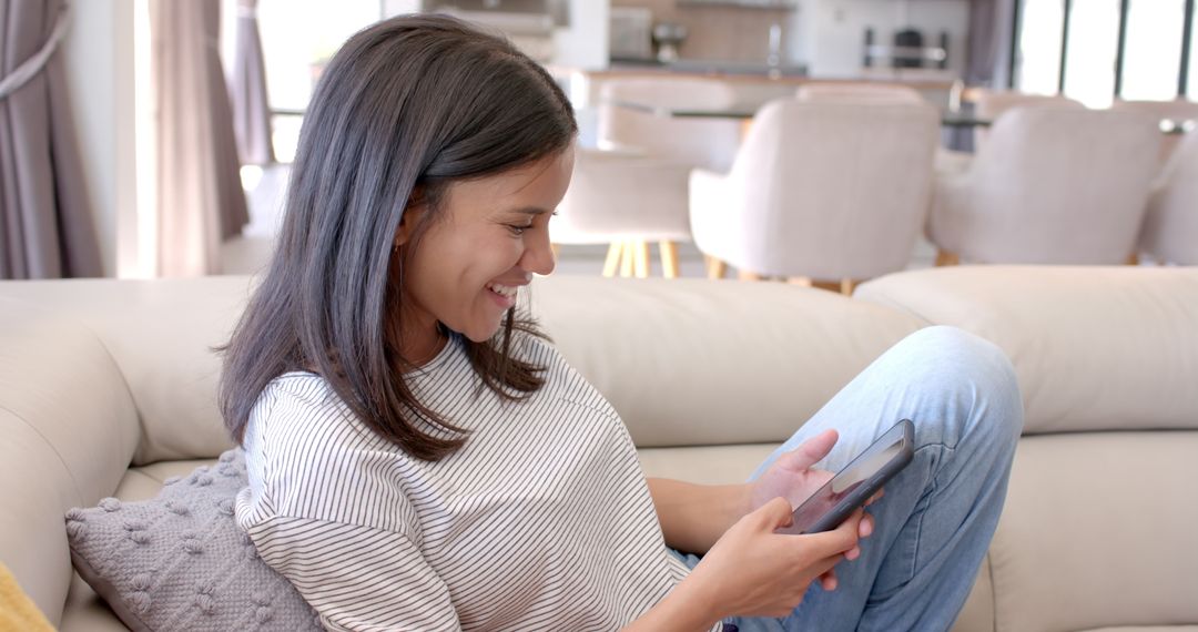 Teen Smiling while Engaging with Smartphone at Home