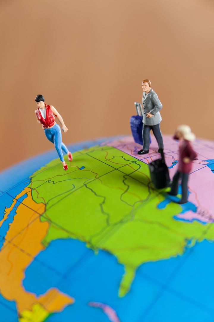 Miniature people travelling on globe - Free Images, Stock Photos and Pictures on Pikwizard.com