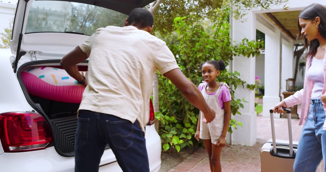 Diverse Family Packing Car for Summer Vacation with Inflatable Float
