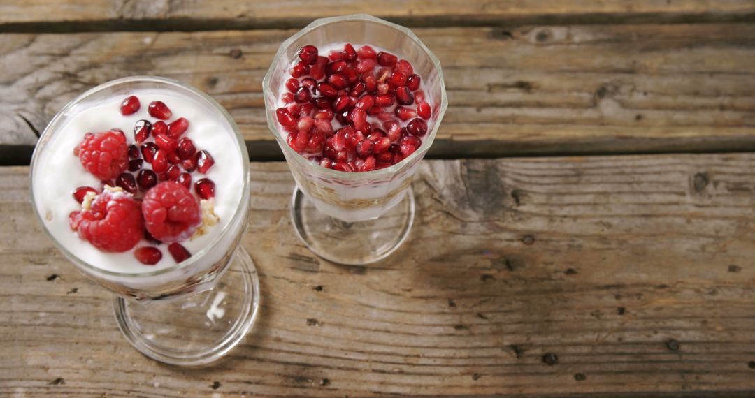 Vibrant yogurt parfaits with raspberries and pomegranate offer a healthy snack. - Free Images, Stock Photos and Pictures on Pikwizard.com