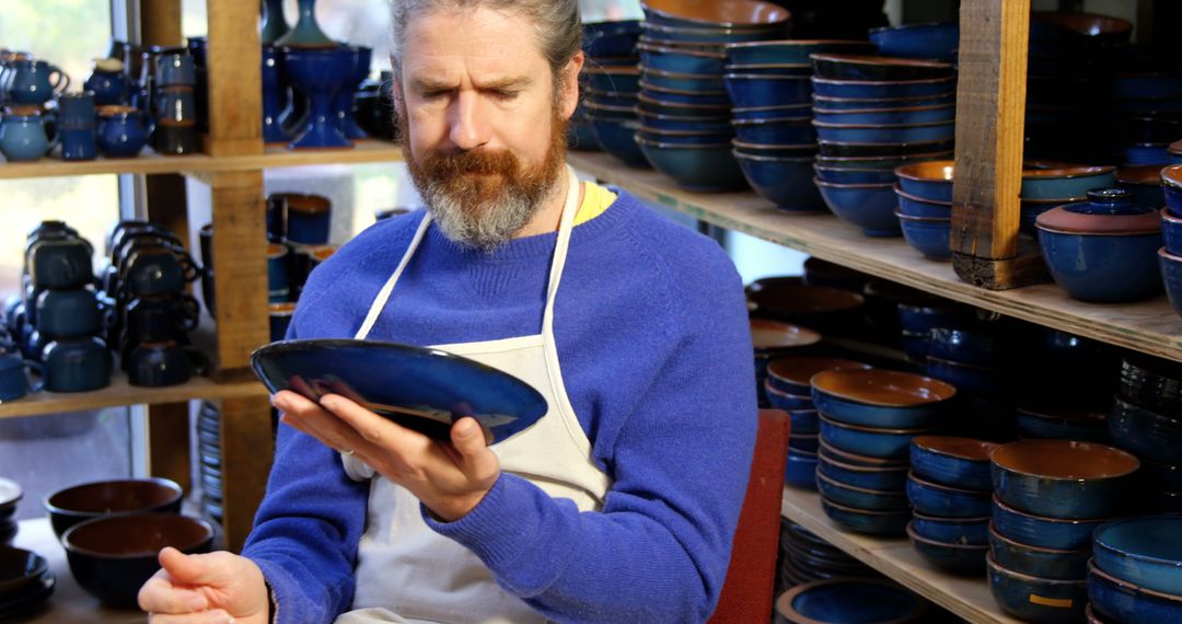 Male Potter Inspecting Handcrafted Ceramic Plate in Studio - Free Images, Stock Photos and Pictures on Pikwizard.com