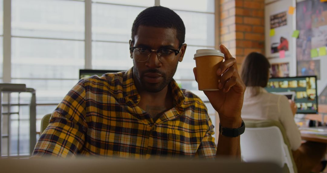 Focused Graphic Designer with Coffee Working in Modern Office