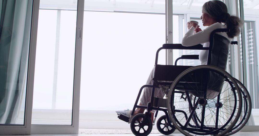 Pensive Woman in Wheelchair Looking Out of Window - Free Images, Stock Photos and Pictures on Pikwizard.com