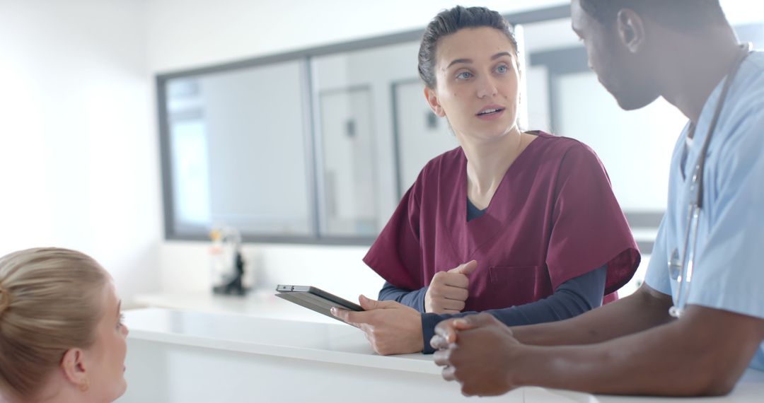 Healthcare Professionals Discussing Patient Care at Reception Desk - Free Images, Stock Photos and Pictures on Pikwizard.com