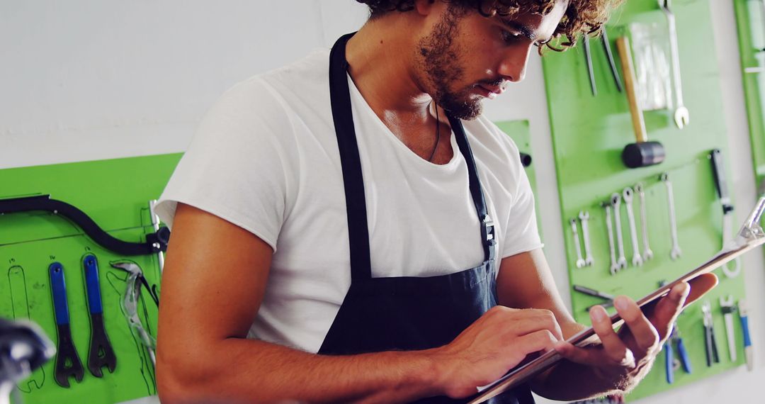 Young Mechanic Utilizing Digital Tablet in Modern Workshop