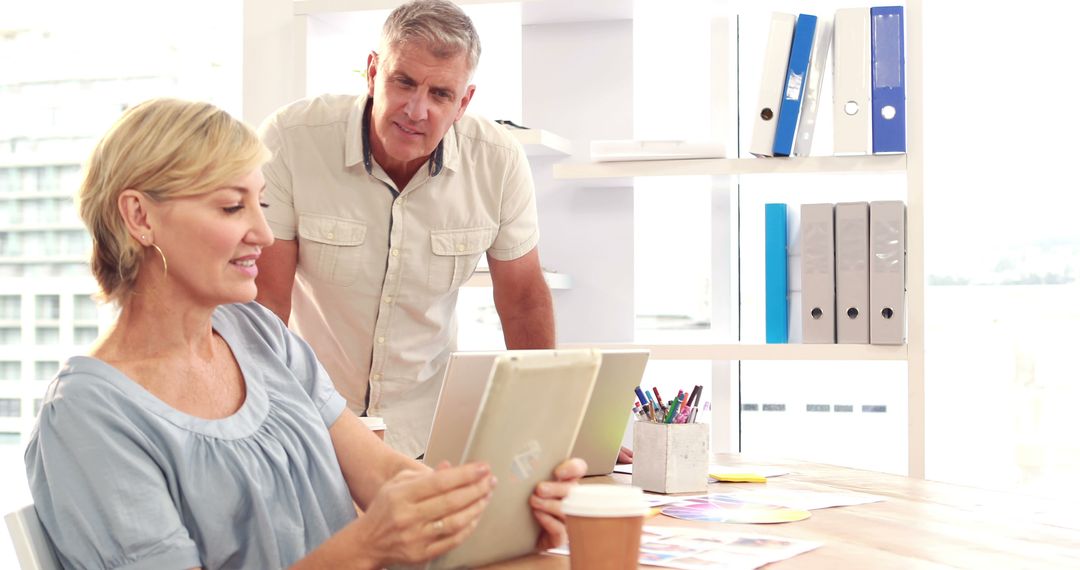 Middle-Aged Colleagues Discussing Digital Strategies in Office