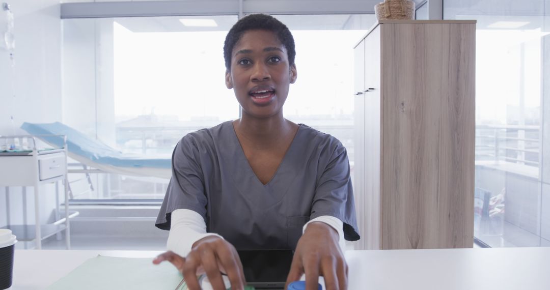 Young Female Nurse Typing on Office Desk in Medical Center - Free Images, Stock Photos and Pictures on Pikwizard.com