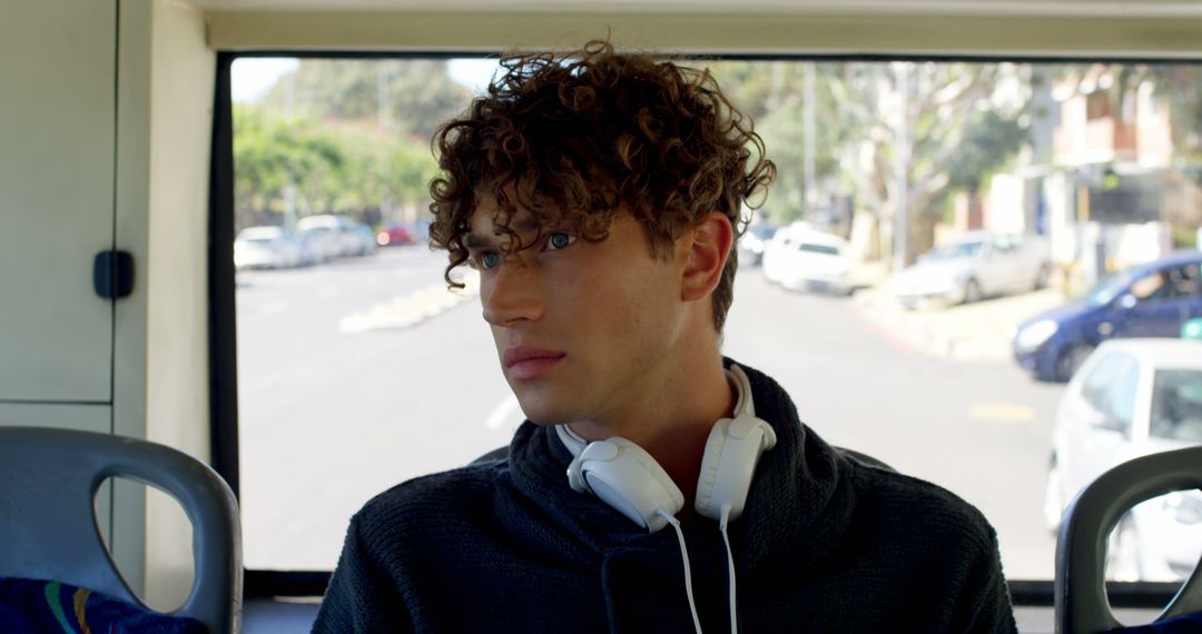 Biracial man sitting in city bus wearing headphones - Free Images, Stock Photos and Pictures on Pikwizard.com