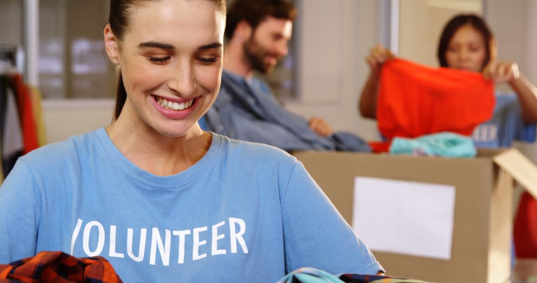 Smiling Female Volunteer Organizing Donation Box at Community Shelter - Free Images, Stock Photos and Pictures on Pikwizard.com