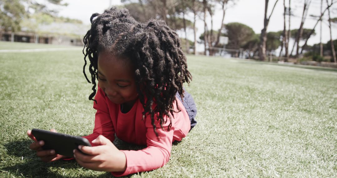 Young Girl Relaxing in Park While Using Smartphone Outdoors
