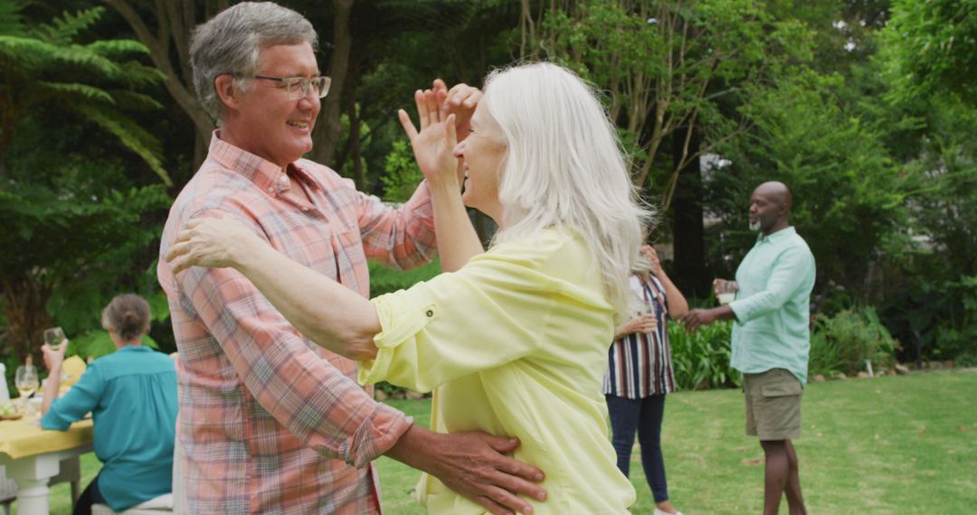 Image of happy caucasian senior couple danging in garden while having lunch with friends - Free Images, Stock Photos and Pictures on Pikwizard.com