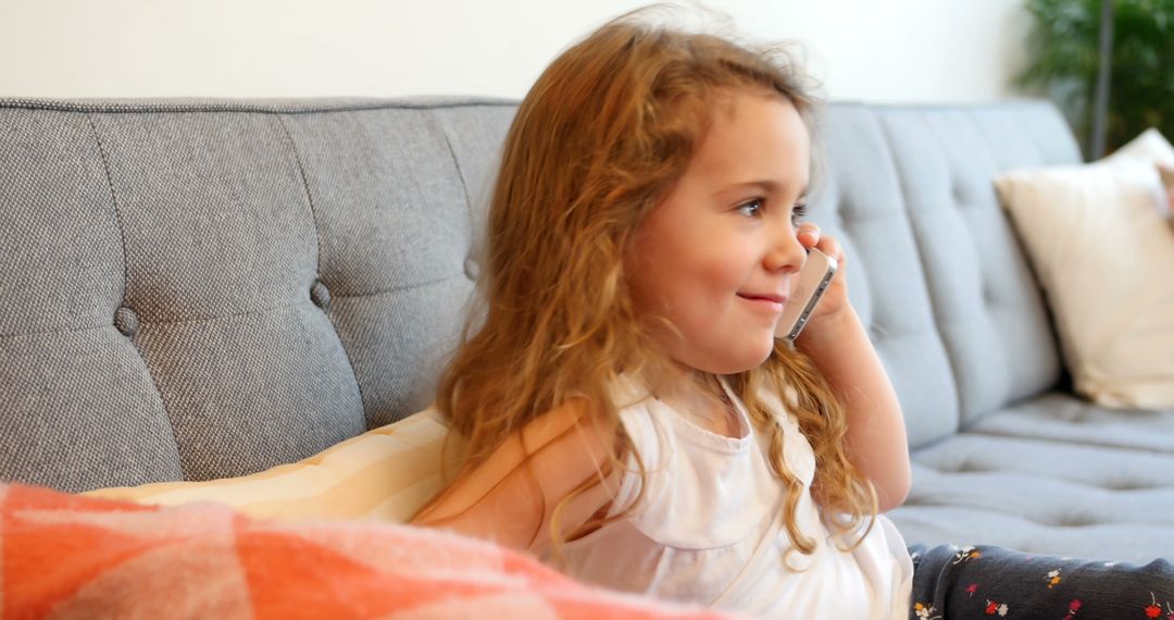 Smiling Young Girl Relaxing on Sofa While Talking on Smartphone - Free Images, Stock Photos and Pictures on Pikwizard.com