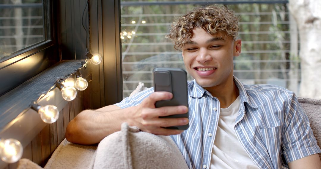 Man Relaxing on Sofa Scrolling Smartphone in Cozy Interior