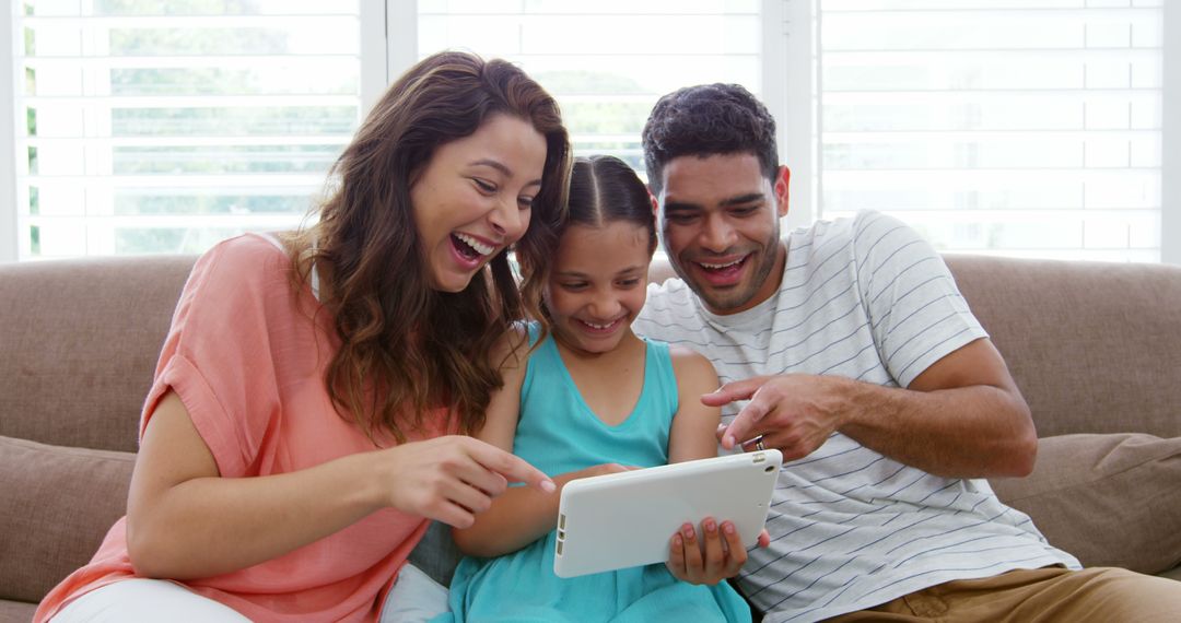 Excited Family Using Tablet Together on Couch - Free Images, Stock Photos and Pictures on Pikwizard.com