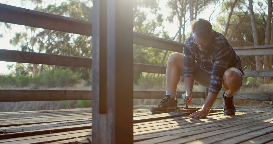 Man Preparing for Hike in Sunny Wooded Area Tying Shoelaces