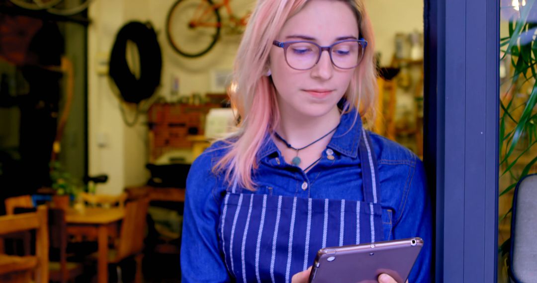 Female Barista Wearing Apron Using Tablet at Coffee Shop - Free Images, Stock Photos and Pictures on Pikwizard.com