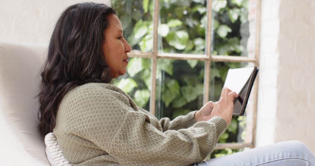 Woman Relaxing with Tablet by Window at Home