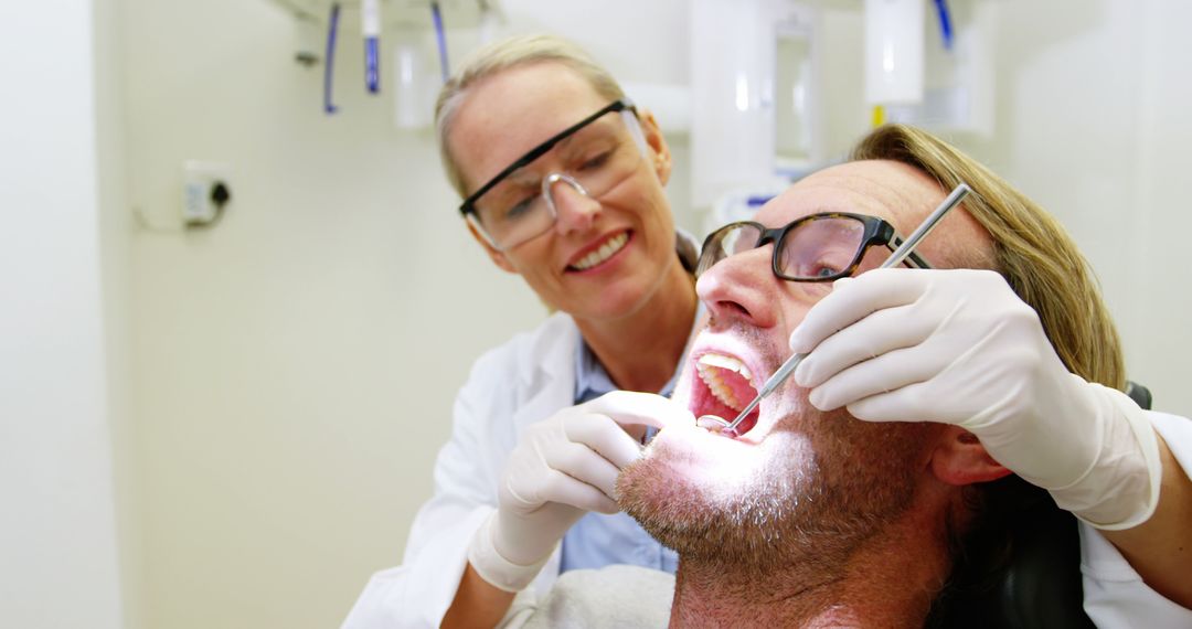 Dentist Examining Male Patient Teeth During Dental Checkup - Free Images, Stock Photos and Pictures on Pikwizard.com