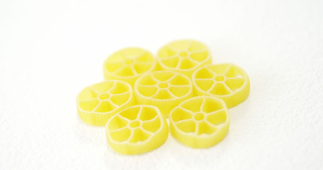 Close-up of Yellow Pasta Wheels on White Background - Free Images, Stock Photos and Pictures on Pikwizard.com