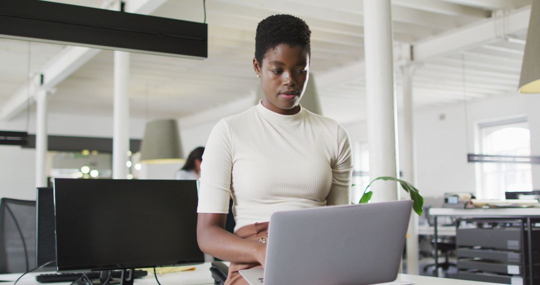 Dedicated Businesswoman Analyzing Data on Laptop at Modern Office