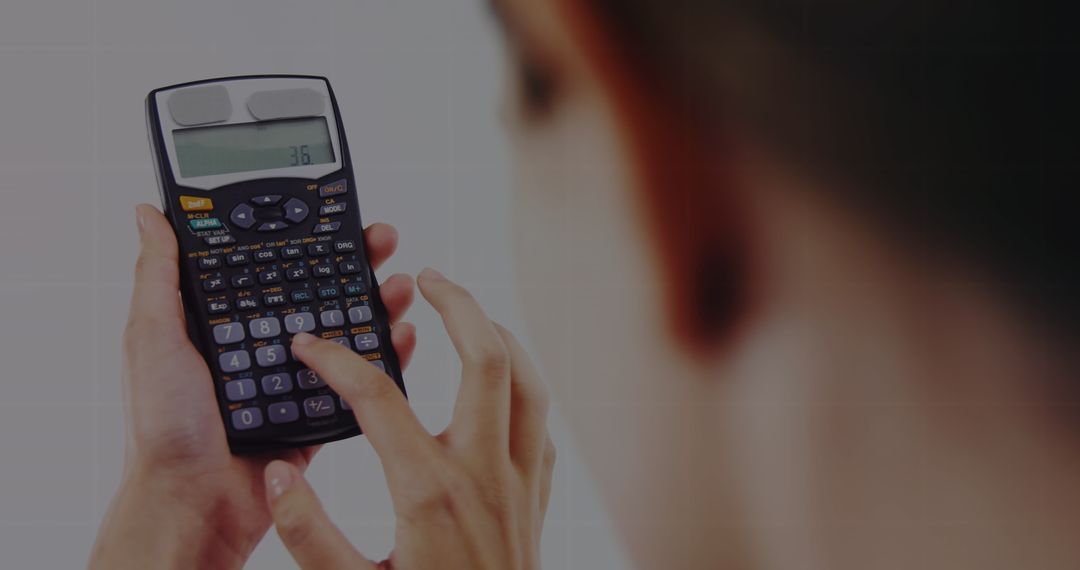Focused Professional Calculating Expenses with Handheld Calculator