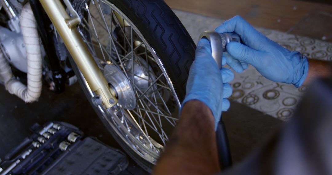 Mechanic Wearing Gloves Checking Motorcycle Tire Pressure - Free Images, Stock Photos and Pictures on Pikwizard.com