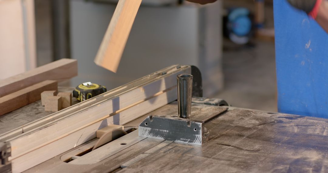 Carpenter Using Push Block on Table Saw for Precise Wood Cutting