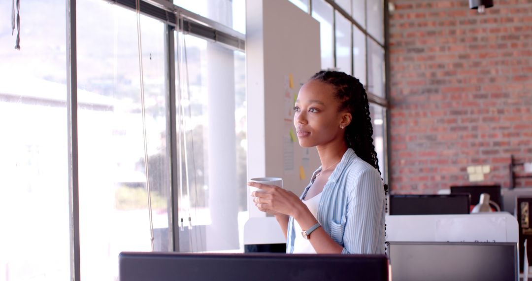 Young Professional Woman Holding Coffee and Looking Out Office Window - Free Images, Stock Photos and Pictures on Pikwizard.com