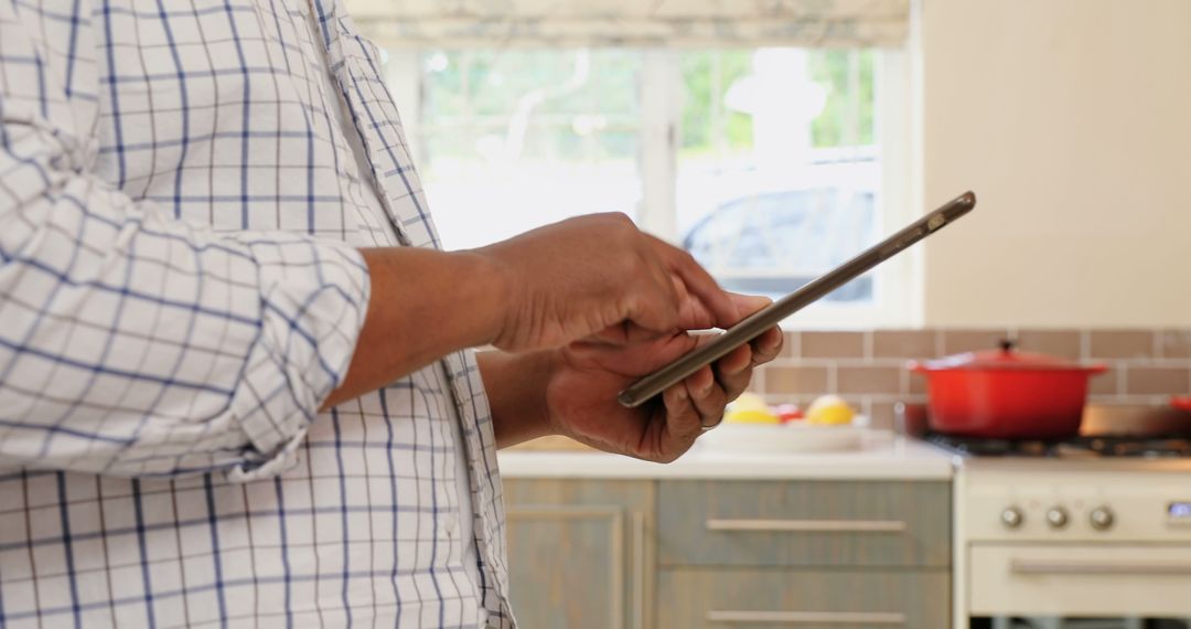 Man Using Tablet in Kitchen for Online Recipe - Free Images, Stock Photos and Pictures on Pikwizard.com