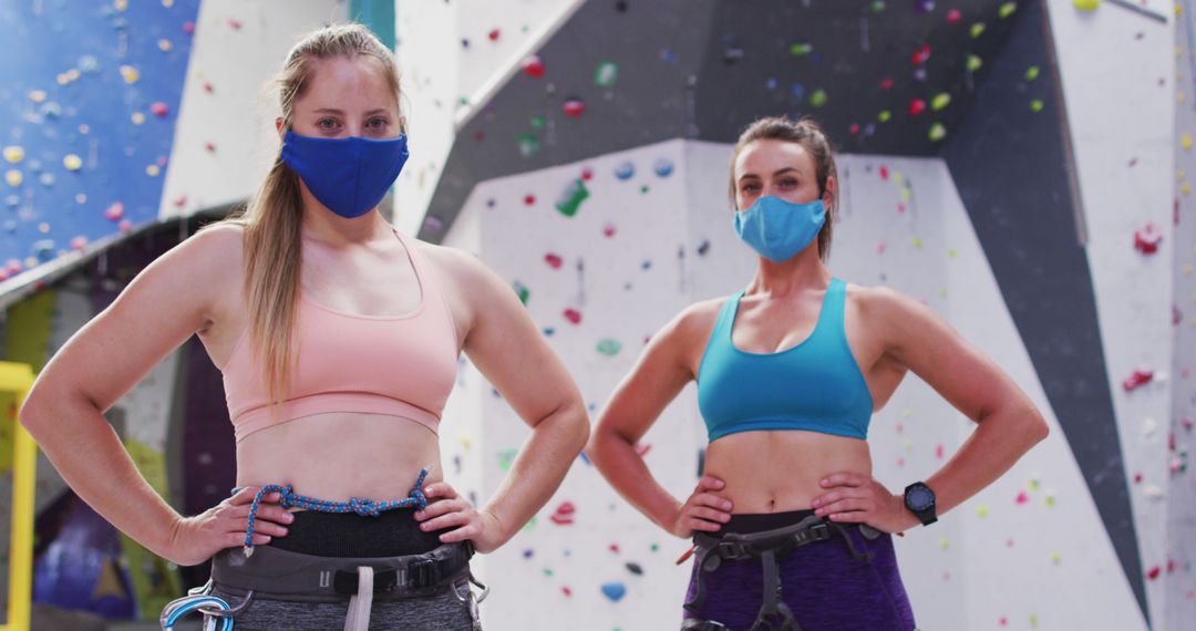 Portrait of two caucasian women wearing face masks standing at indoor climbing wall - Free Images, Stock Photos and Pictures on Pikwizard.com