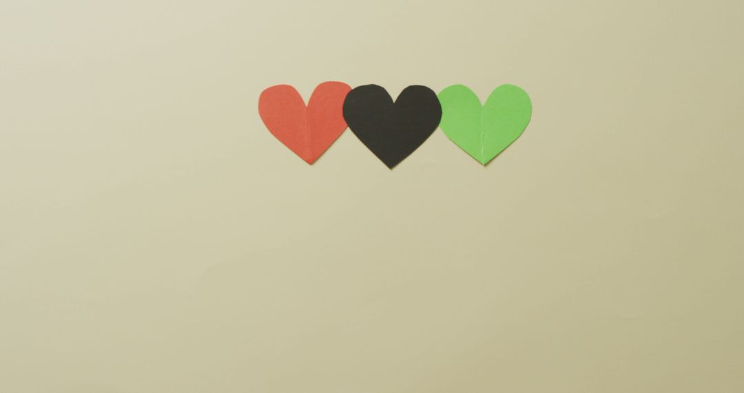 Row of Red, Black, and Green Paper Hearts on Beige Background - Free Images, Stock Photos and Pictures on Pikwizard.com