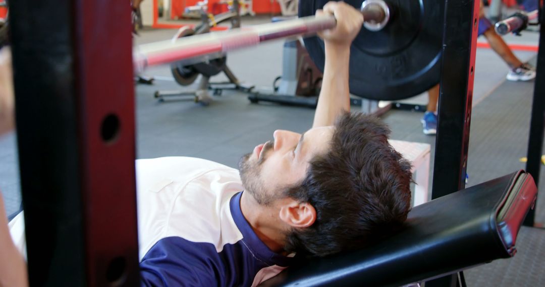 Young Man Bench Pressing at Gym - Free Images, Stock Photos and Pictures on Pikwizard.com