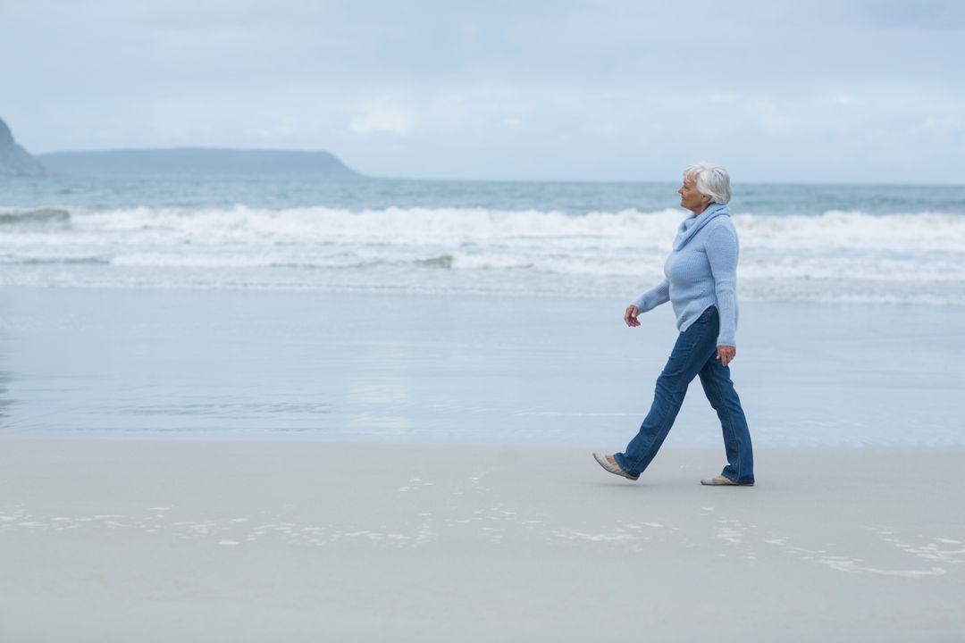 Senior woman walking on the beach - Free Images, Stock Photos and Pictures on Pikwizard.com