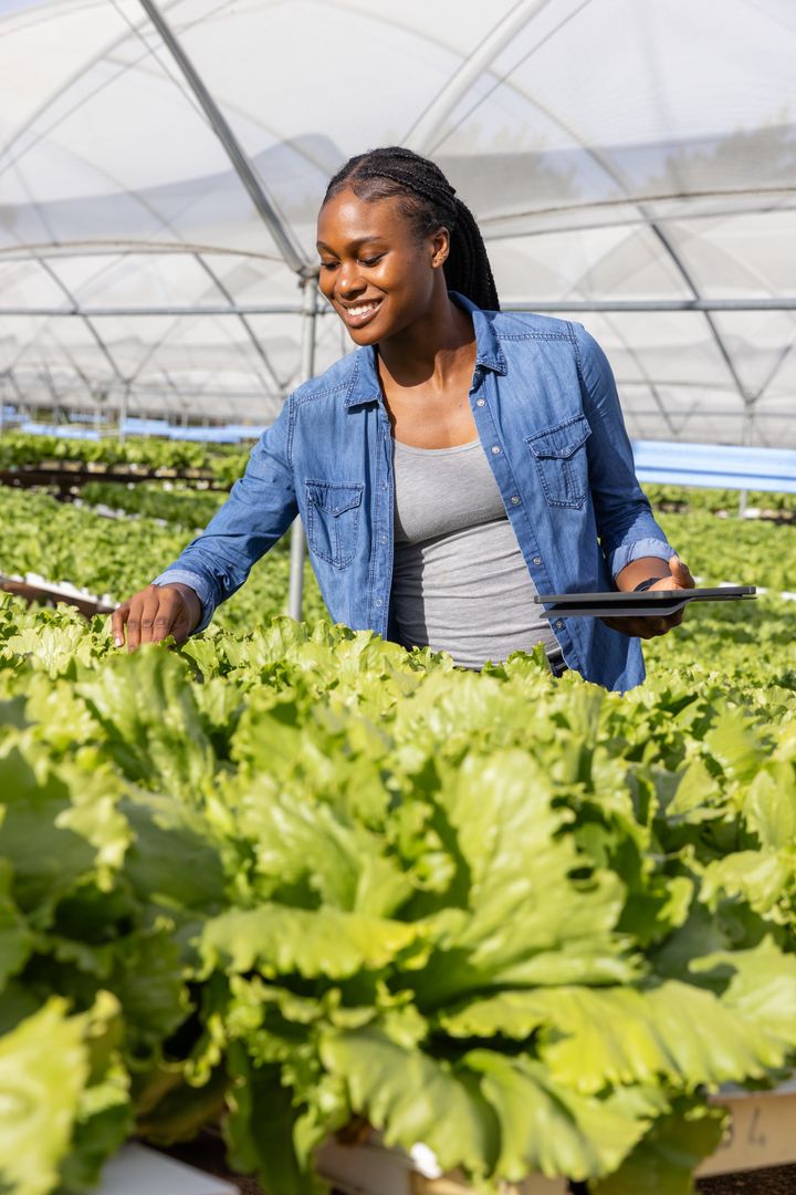 African American Woman Using Tablet in High-Tech Greenhouse