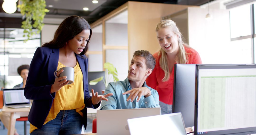 Diverse Team Collaborating with Laptop in Casual Office Environment