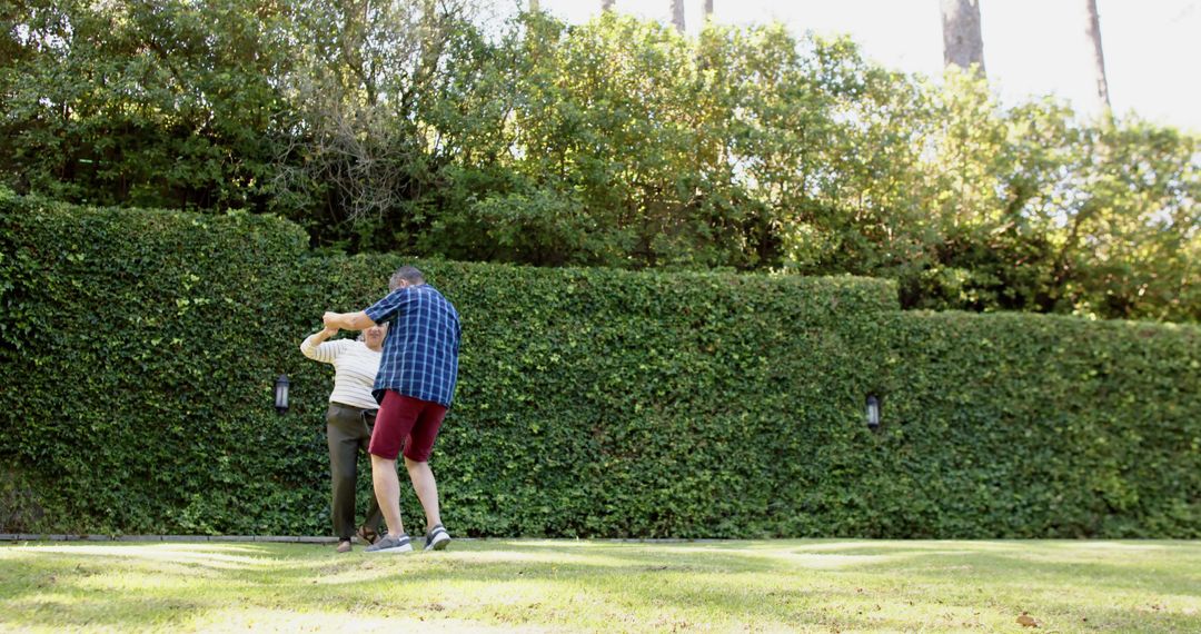 Elderly couple dancing in backyard garden - Free Images, Stock Photos and Pictures on Pikwizard.com