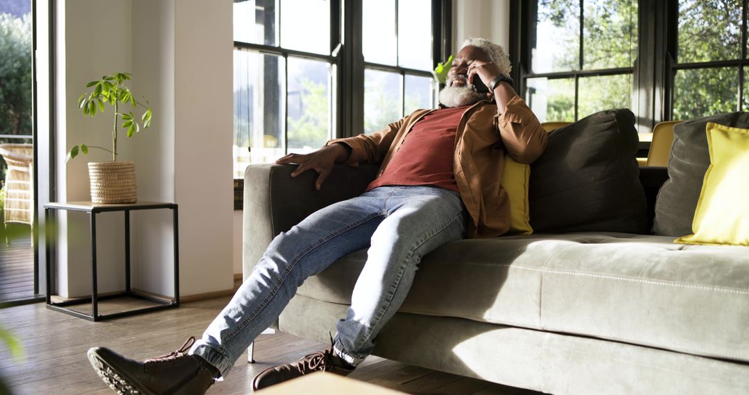 Senior Man Relaxing on Sofa While Speaking on Smartphone