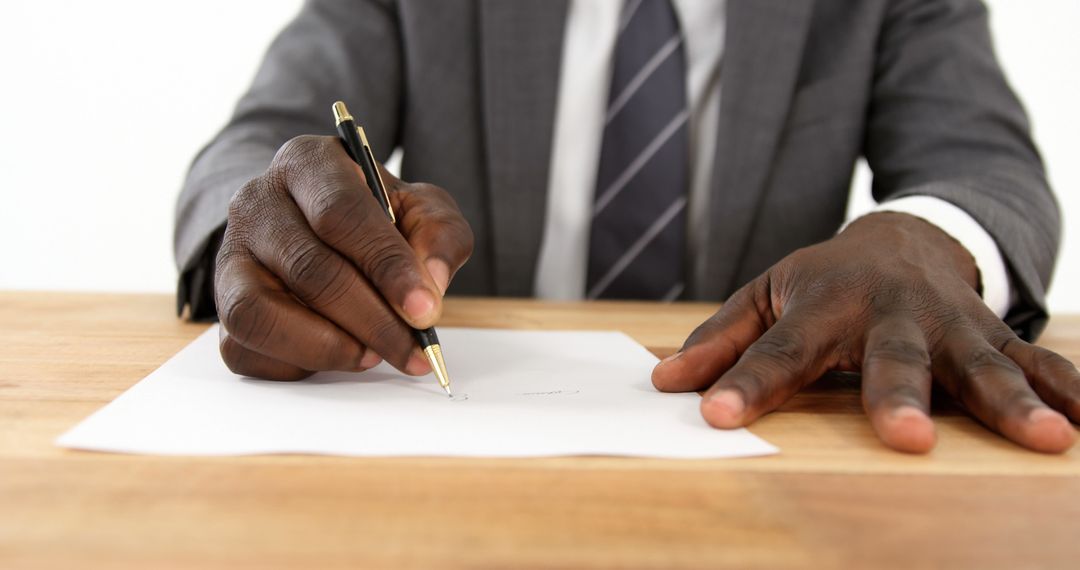 Businessman Signing Important Document at Office Desk - Free Images, Stock Photos and Pictures on Pikwizard.com