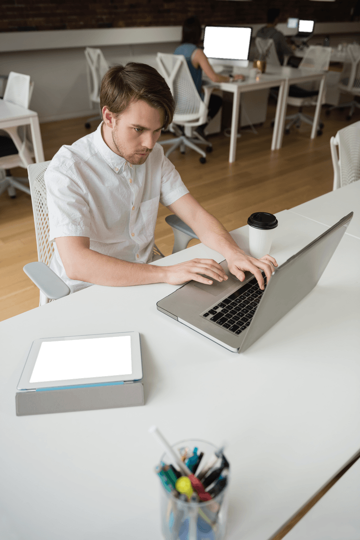 Focused Professional Using Laptop in Modern Office Transparent Environment