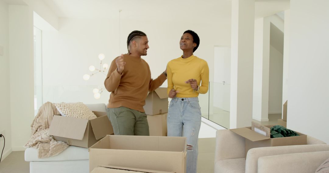 Diverse Couple Dancing Amongst Moving Boxes in New Home
