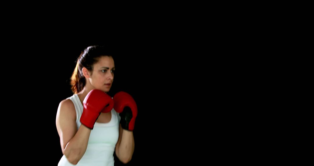 Focused Female Boxer Stance in Black Studio Background - Free Images, Stock Photos and Pictures on Pikwizard.com