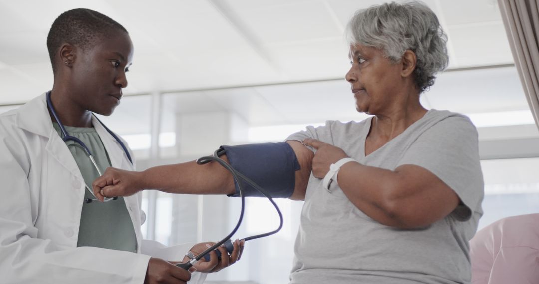 Doctor Checking Blood Pressure of Older Female Patient in Hospital - Free Images, Stock Photos and Pictures on Pikwizard.com