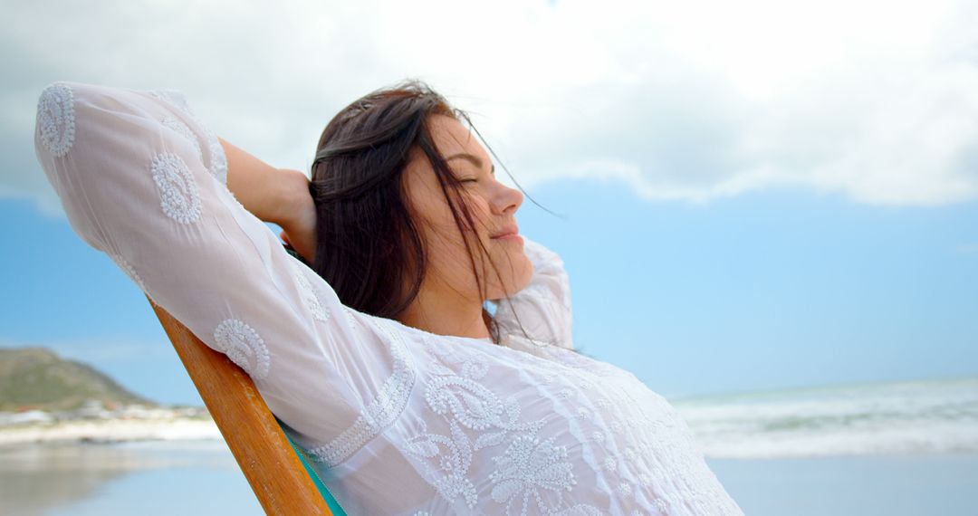 Young Woman Relaxing at Beach in White Dress - Free Images, Stock Photos and Pictures on Pikwizard.com