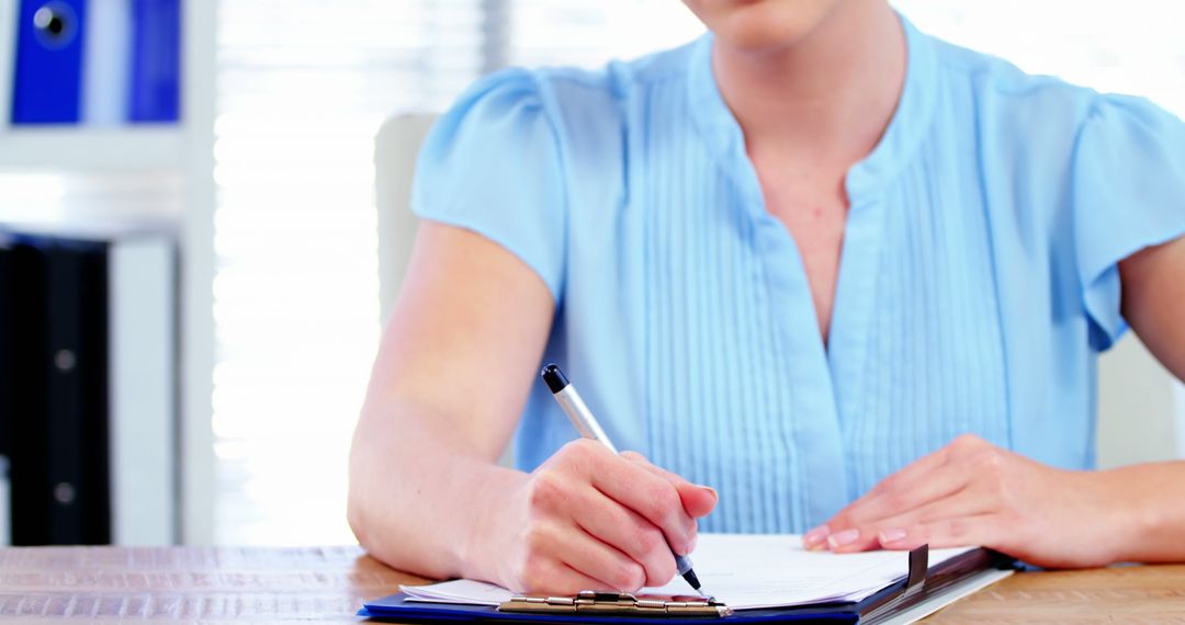 Businesswoman Writing Notes in Home Office Workspace - Free Images, Stock Photos and Pictures on Pikwizard.com